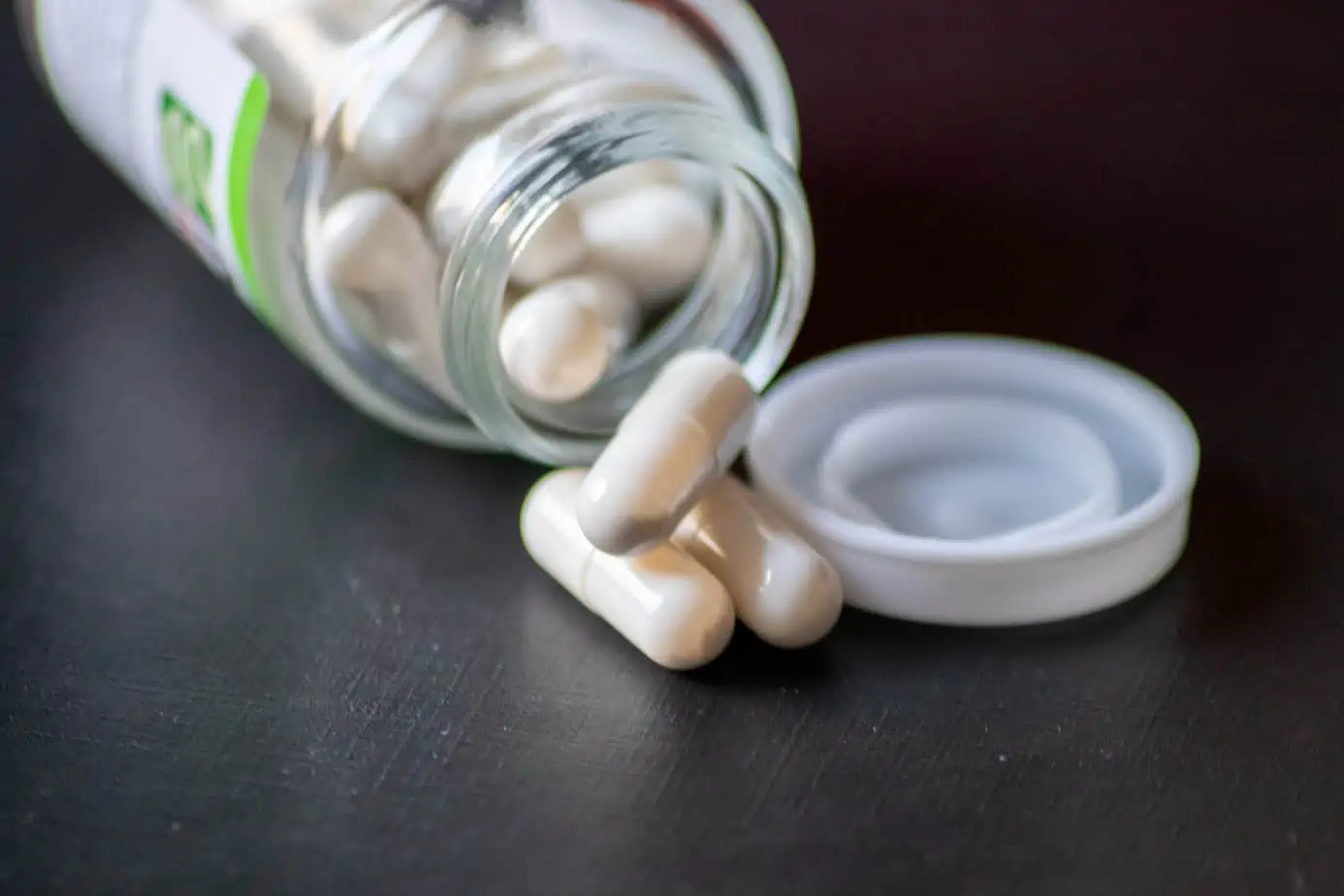 bottle full of white pills spilled over