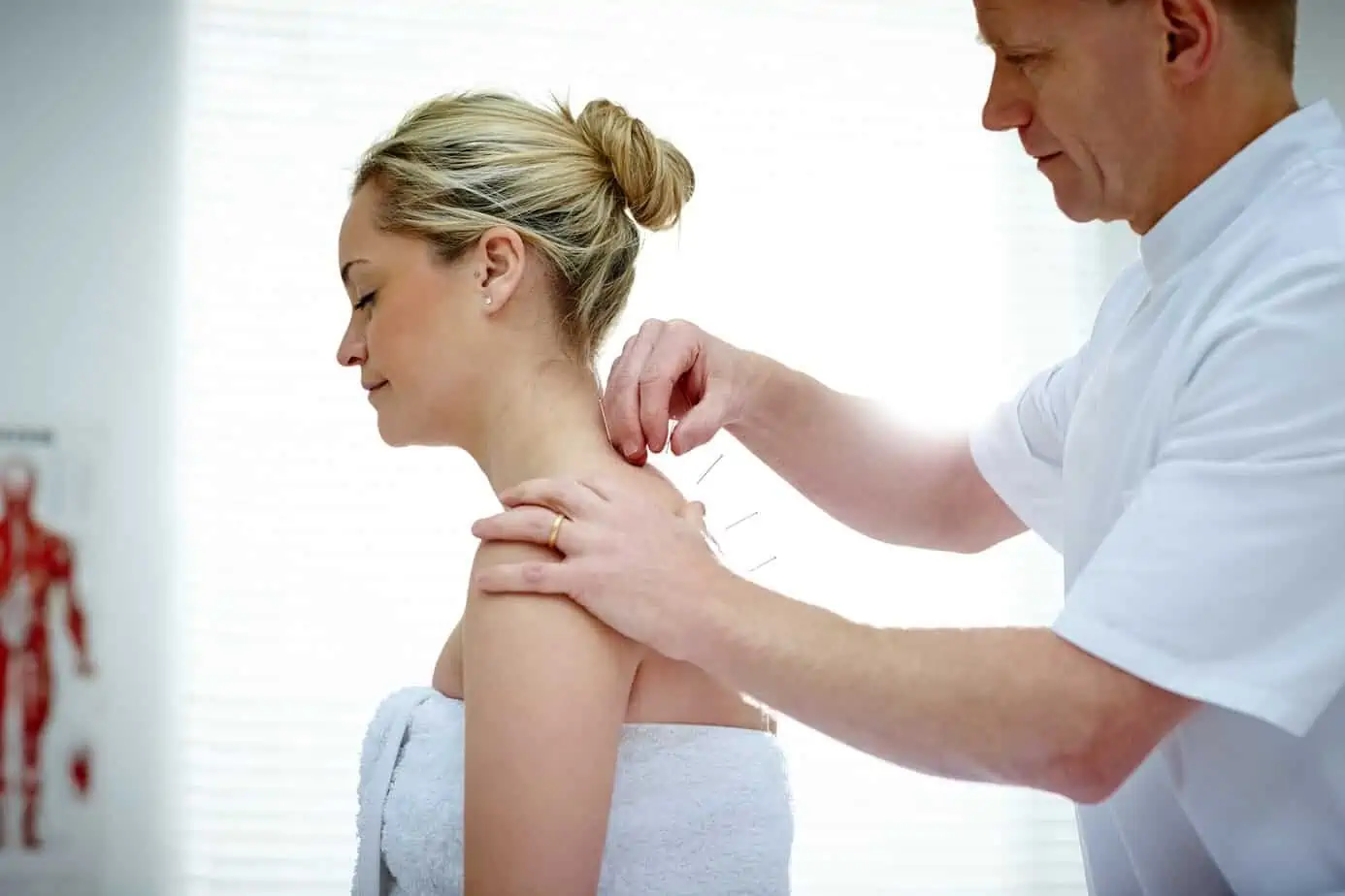 woman undergoes acupuncture treatment in office