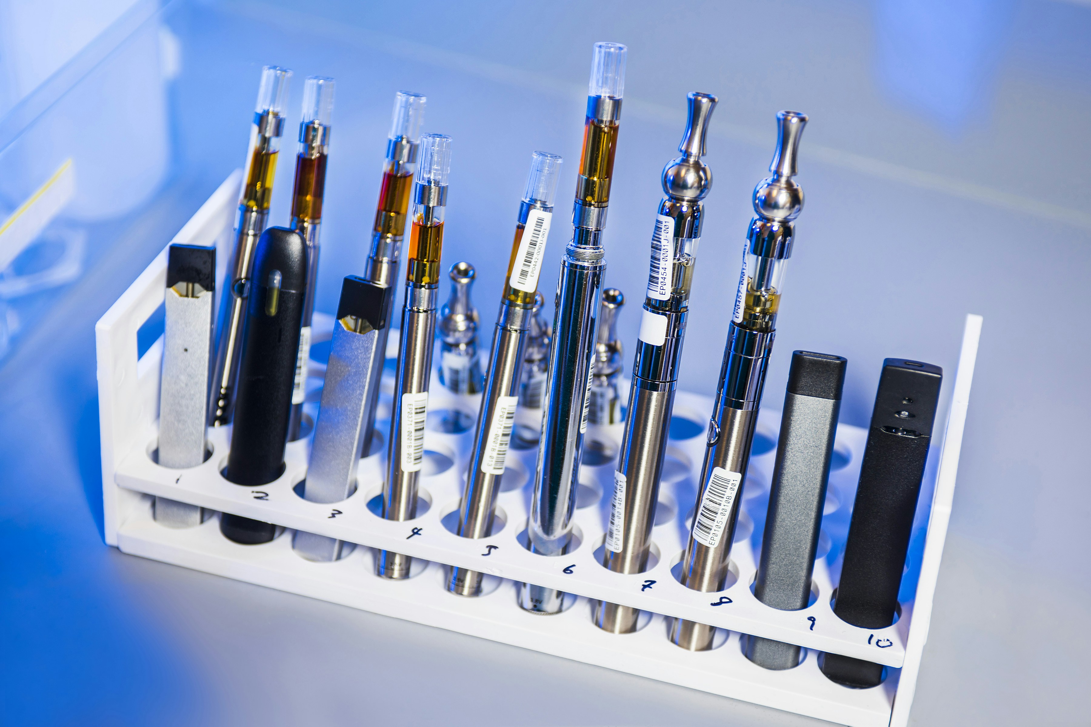 Different types of vapes and cartridges are showcased in a container
