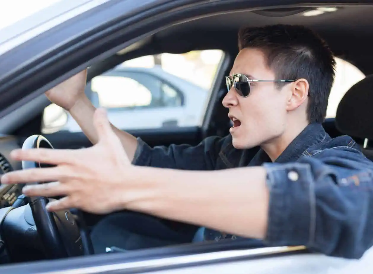 man in car getting angry while driving and make irritated gesture