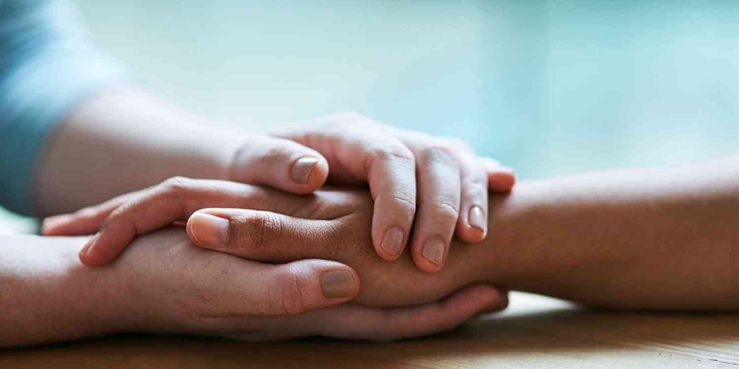 close up of hands holding in recovery support group