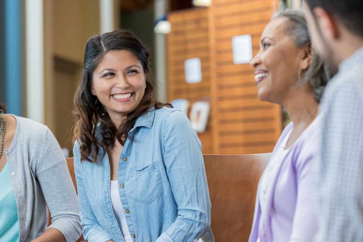 Women smiling at an in-person family support group meeting at Mountainside Chappaqua