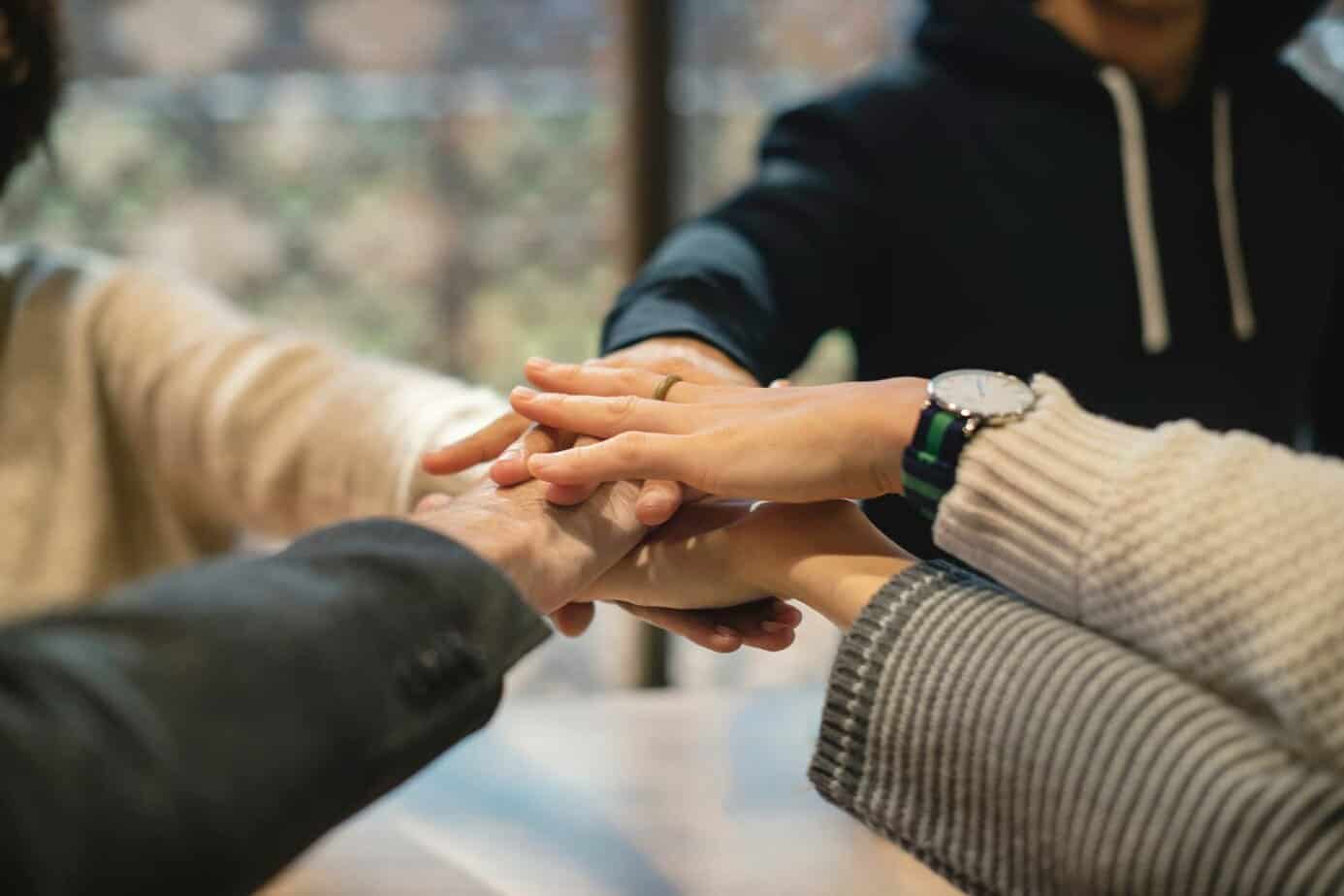 hands of people in recovery reaching out for support