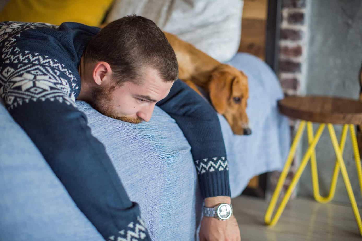 a man is coping with depression lying on the bed with his dog