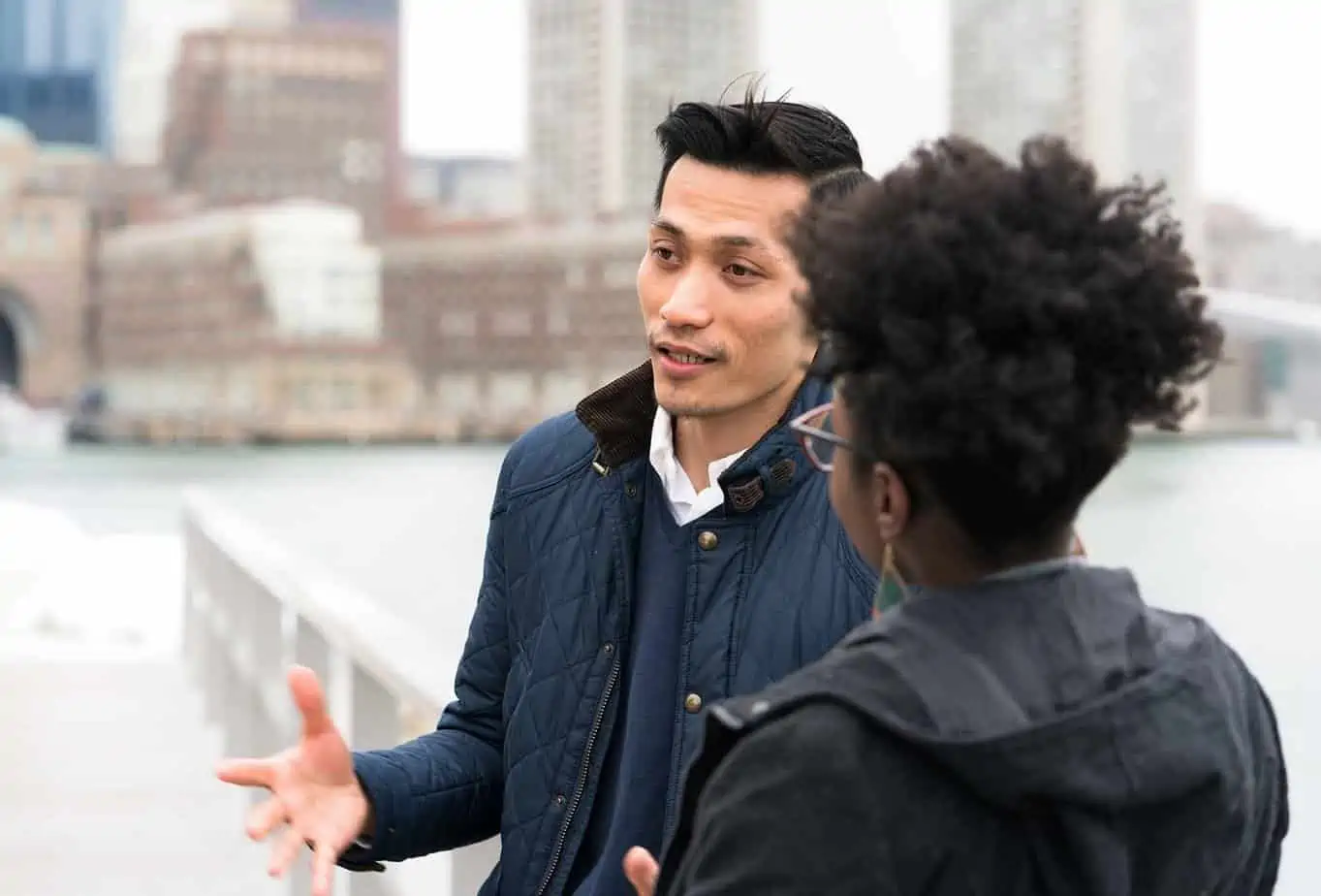 man sharing his addiction recovery story with a peer outside on bridge