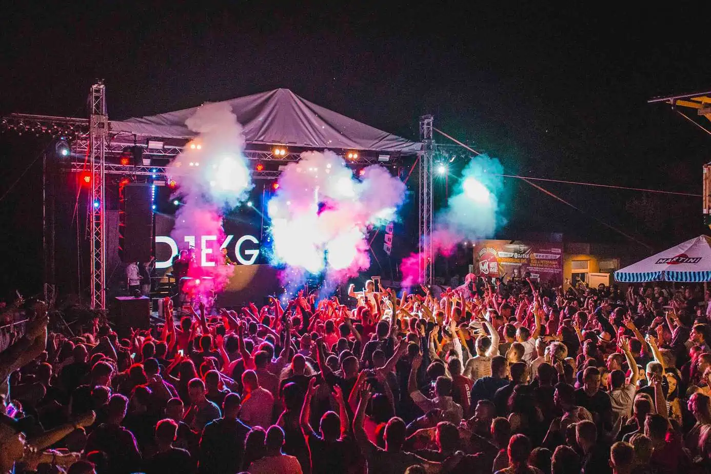 crowd of people partying at music festival in front of stage
