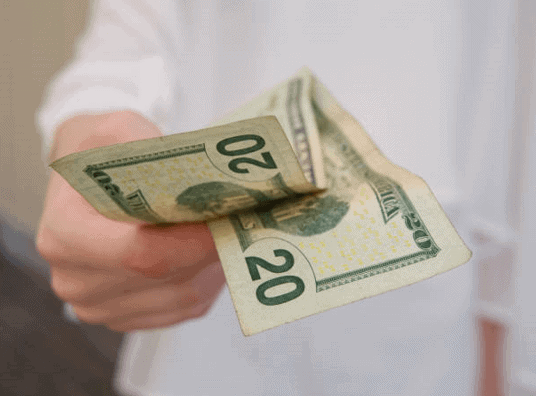 hand holding a $20 bill for financing