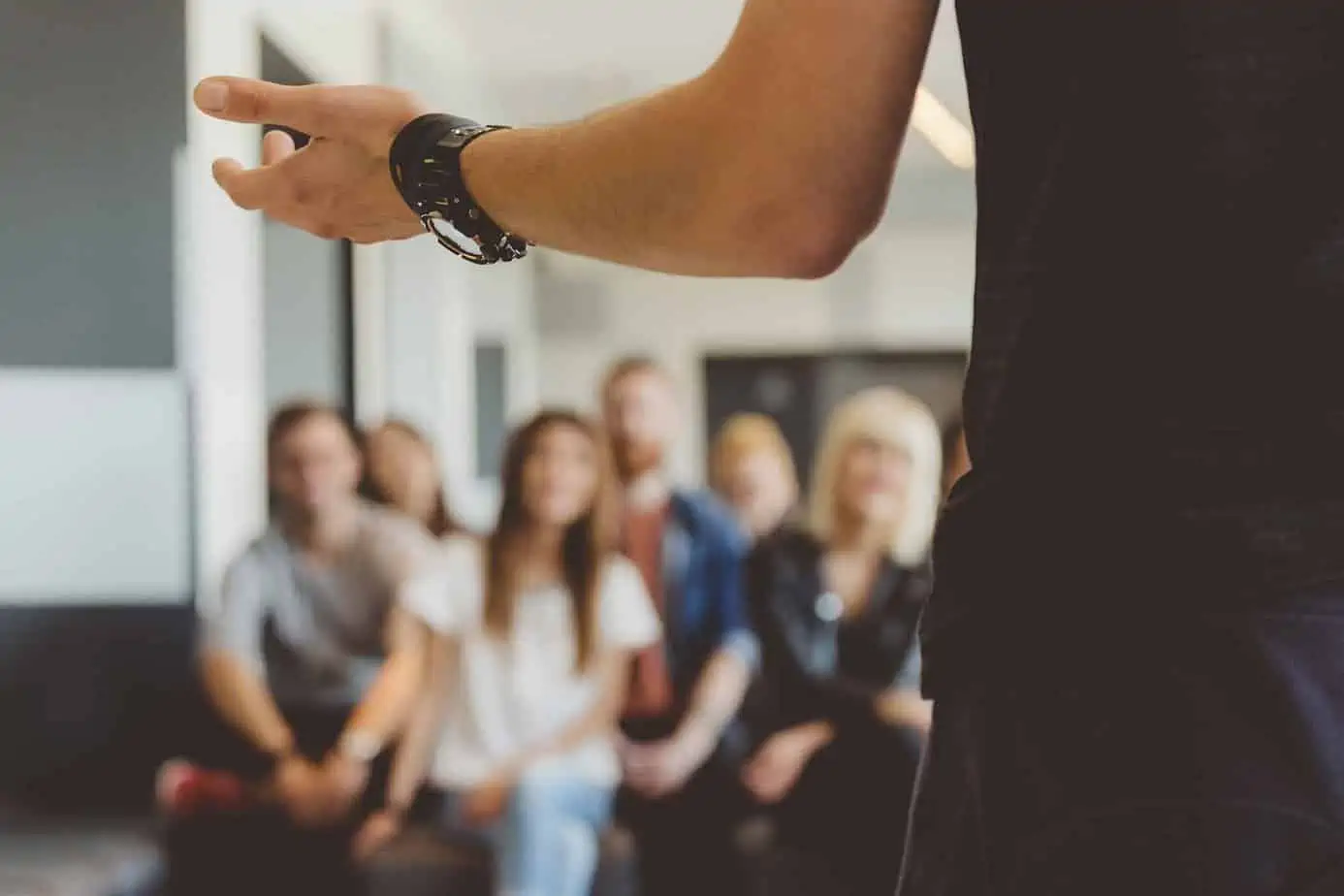 A person speaking to a group of people in a conferfence, meeting or support group.