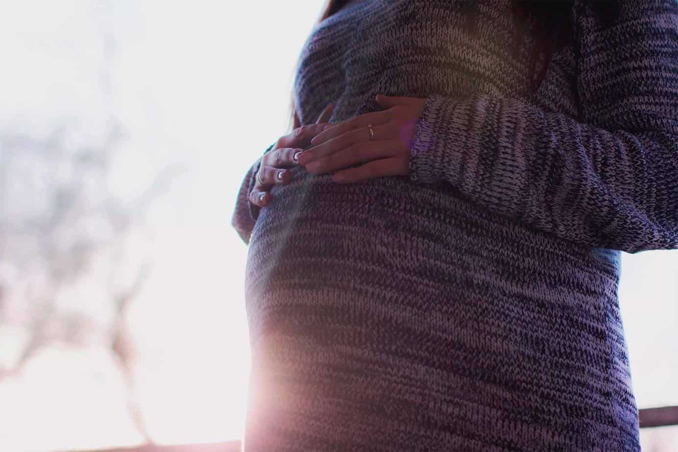pregnant woman resting hands on her stomach