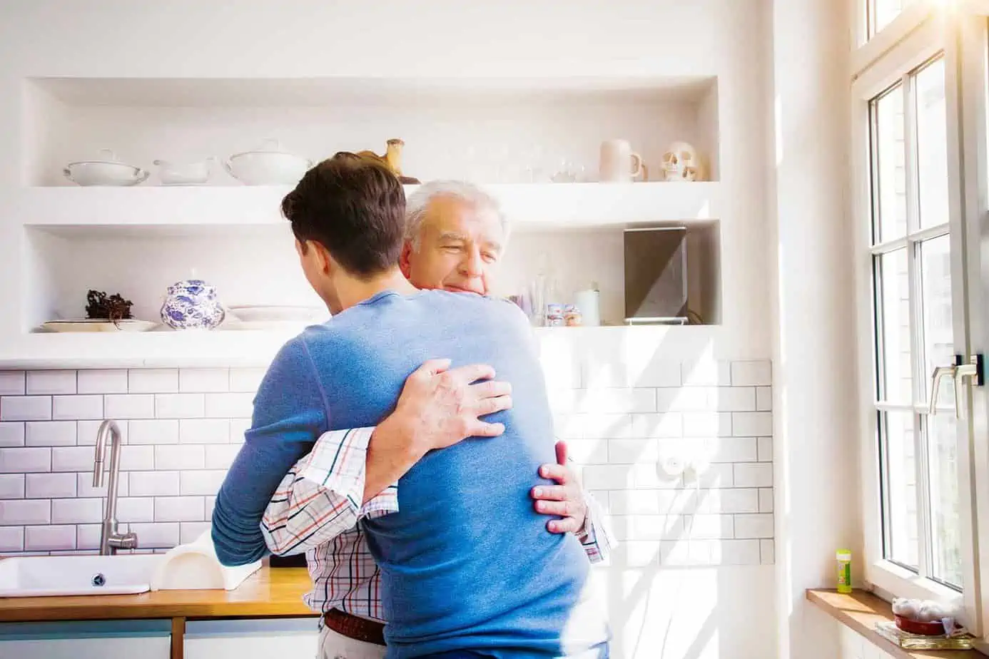 father hugging and practicing forgiveness with his son in recovery.
