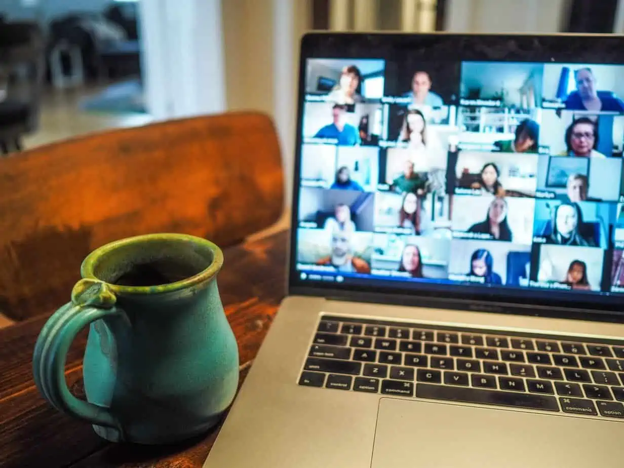 Laptop with Zoom meeting open, coffee mug on table, Alcoholics Anonymous, 12 step recovery support group