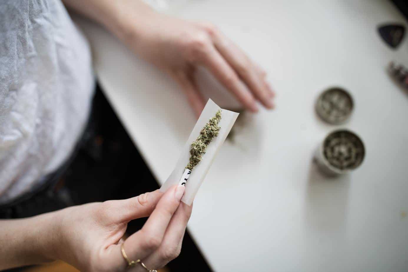 young person rolling a marijuana cigarette