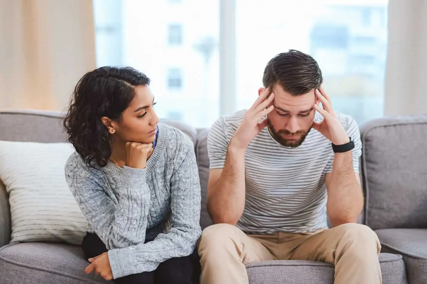 Woman sits on couch supporting a man experiencing a trigger in recovery