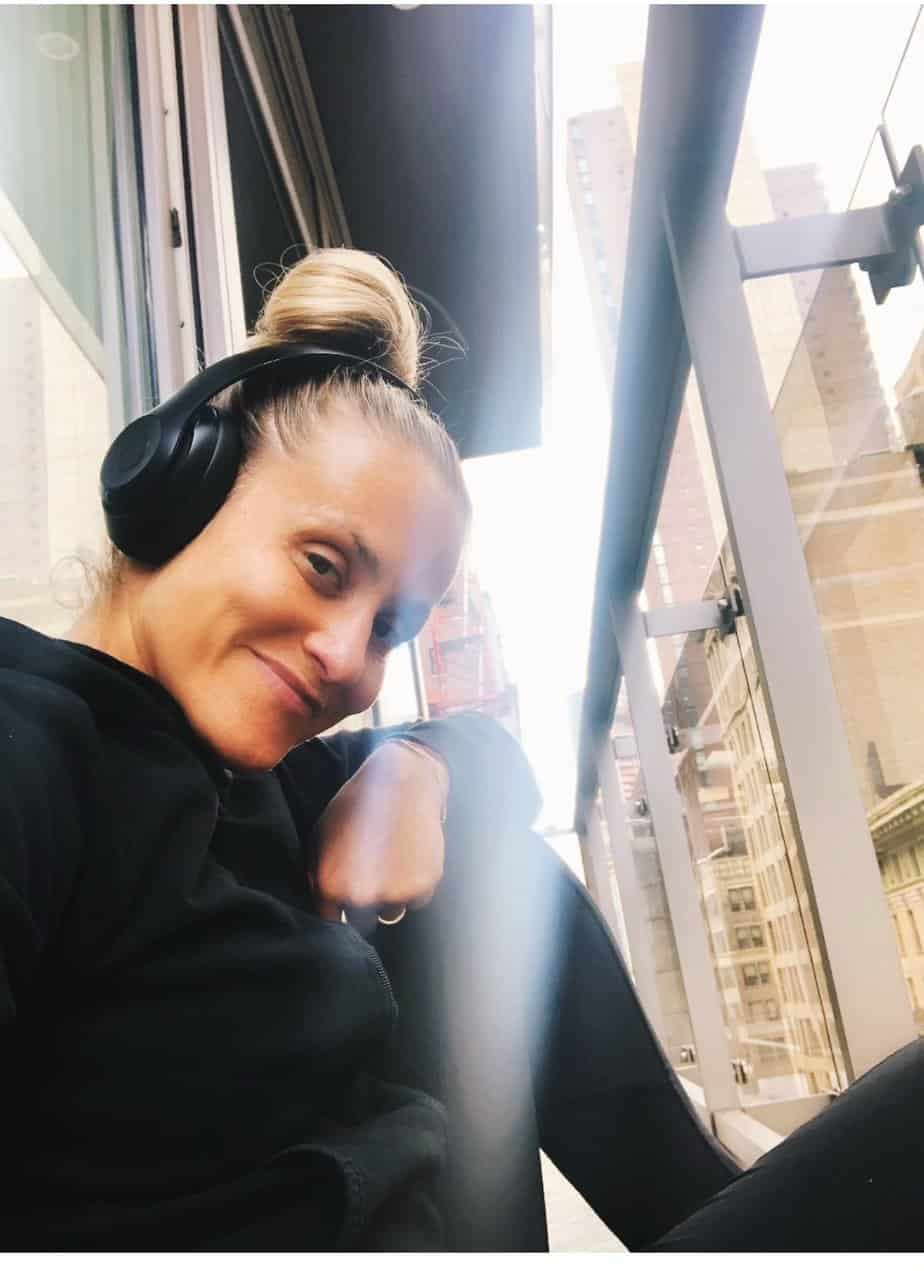 woman wearing headphones takes selfie in gym