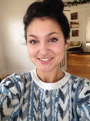 woman in colorful jumper takes selfie in home
