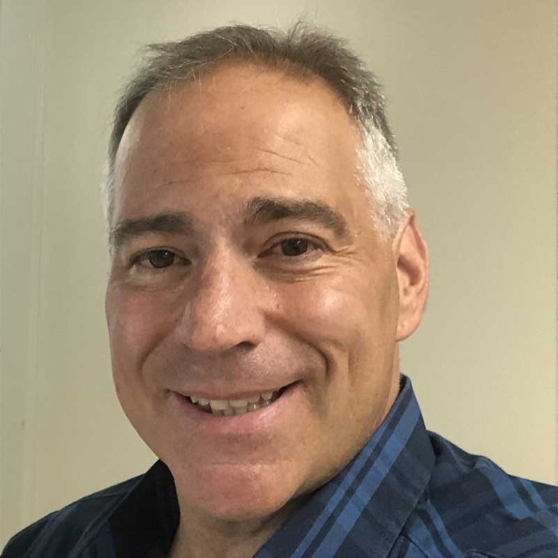 smiling older man in blue collared shirt