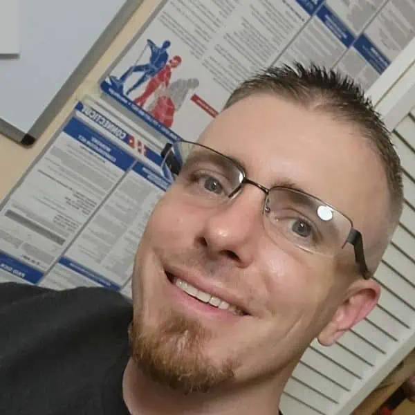man in glasses smiling seated in office
