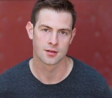 headshot of man against red backgroun