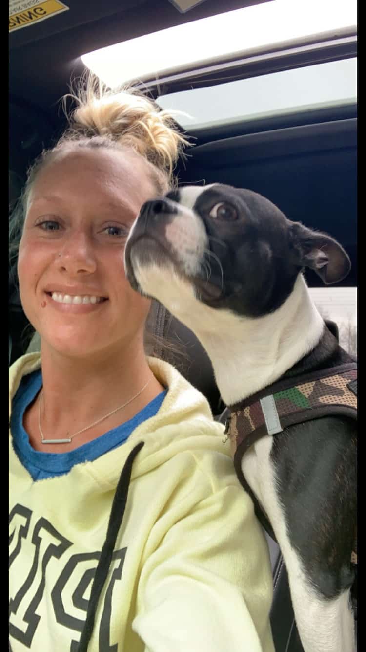 smiling woman in car accompanied by dog