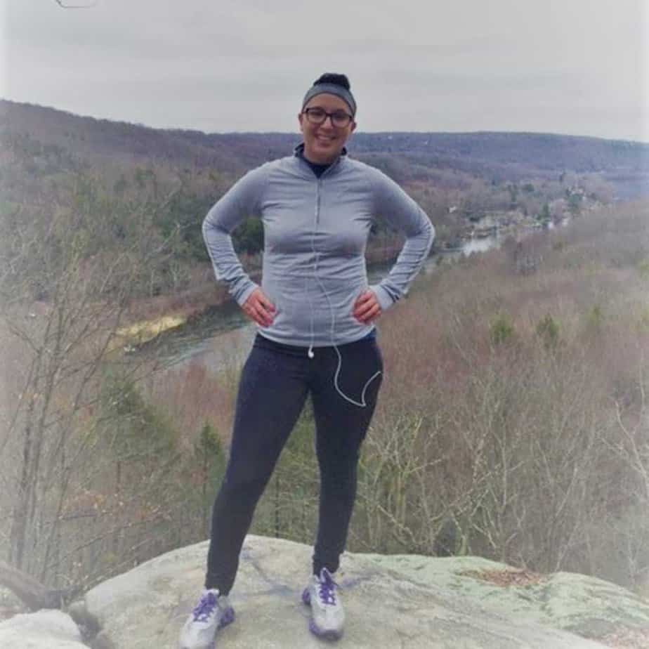 woman posing confidently on mountain in forest