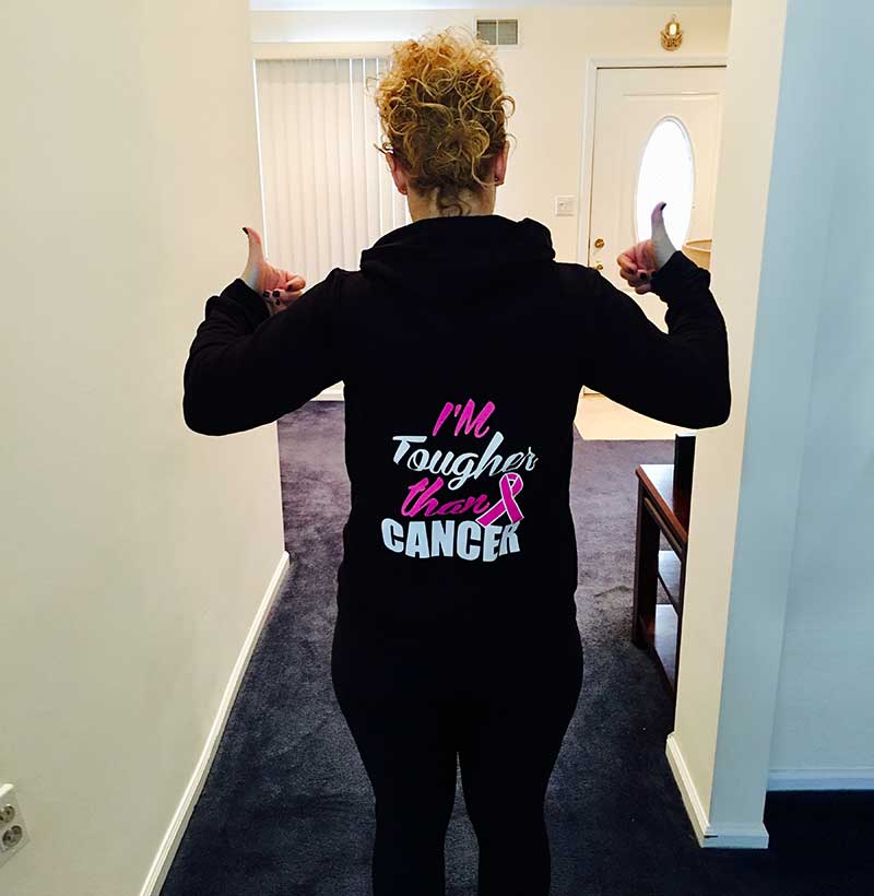 woman in inspiring cancer sweatshirt with thumbs up