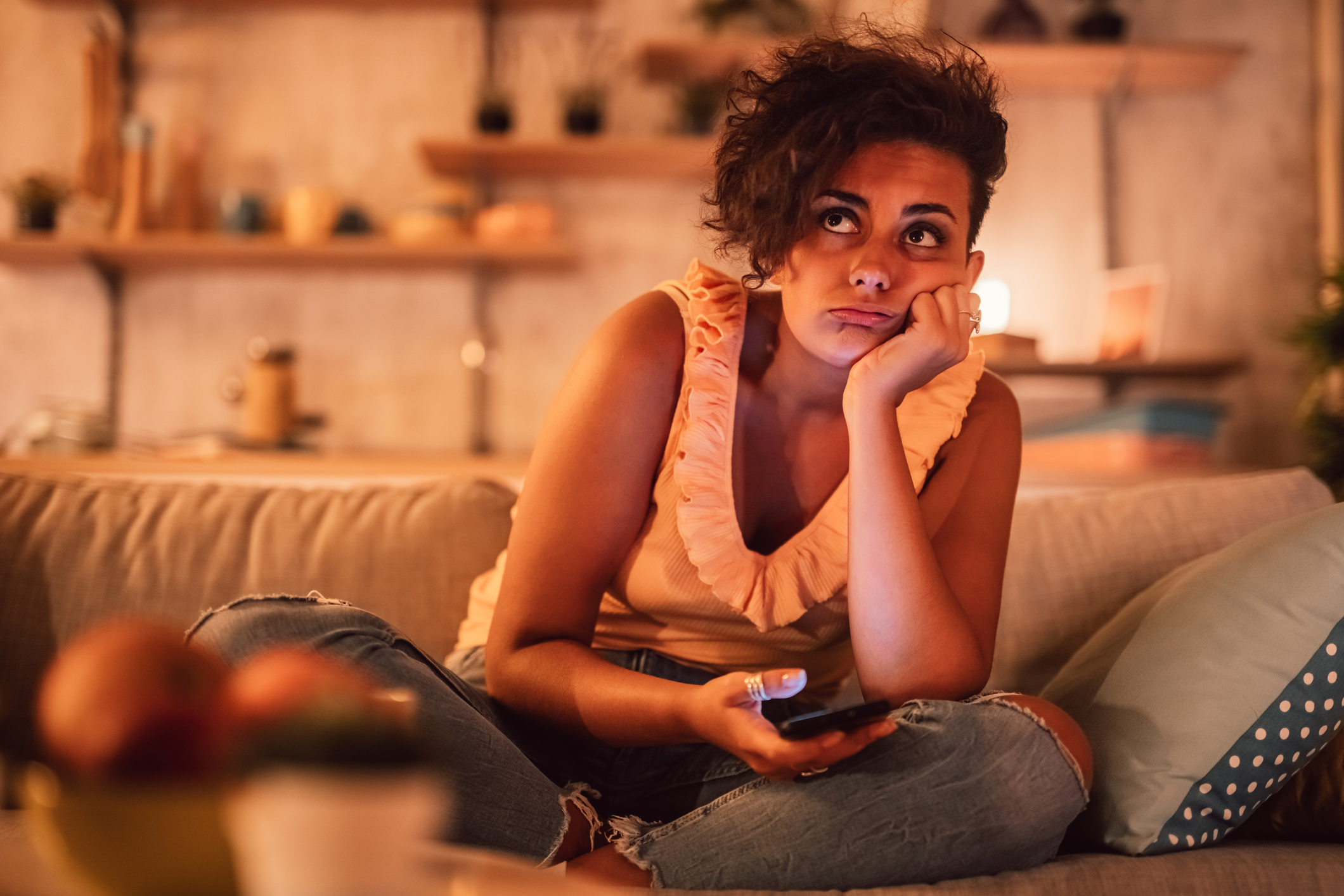 woman struggling with acute trauma sits on couch having flashbacks.