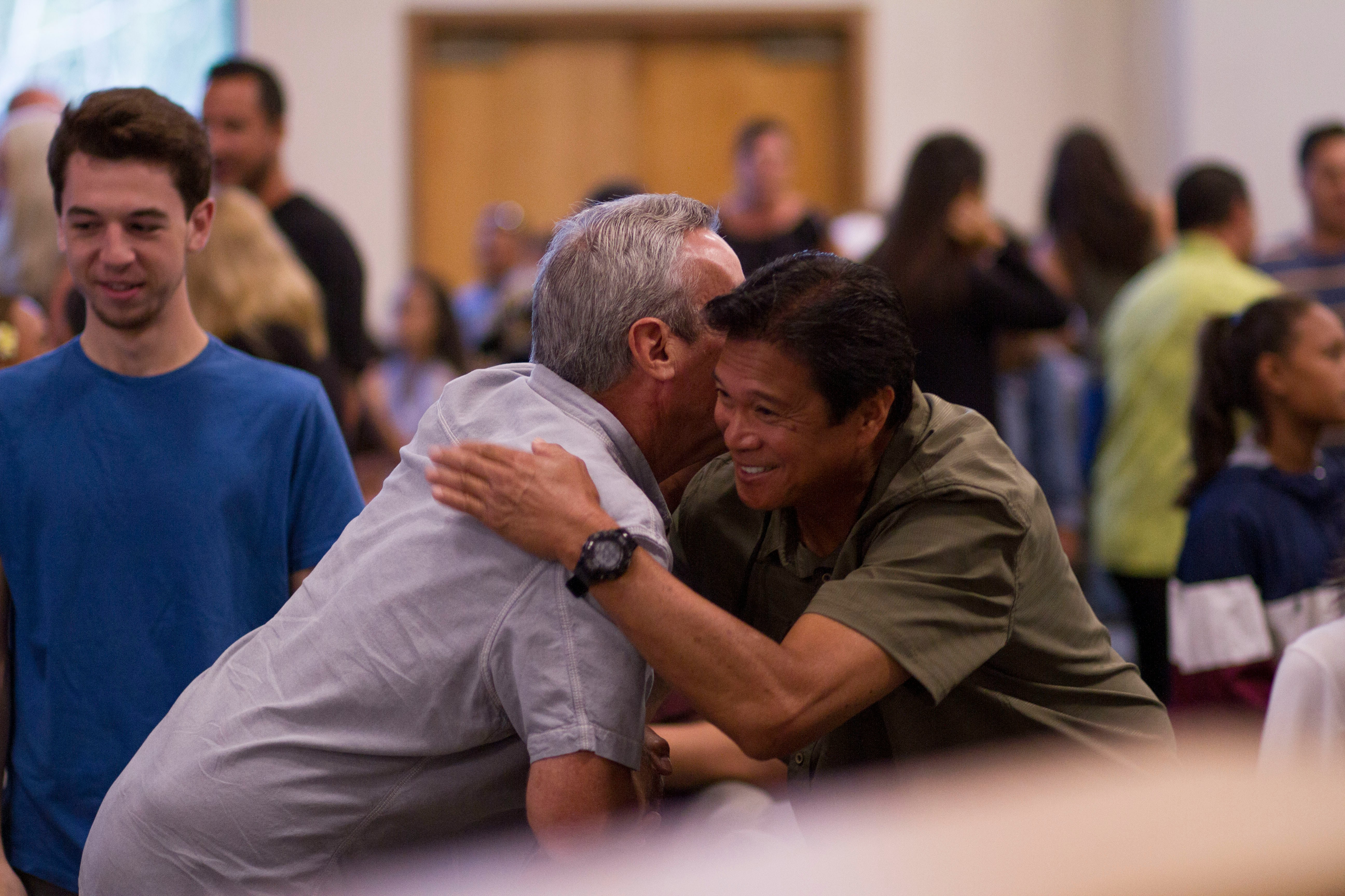 man hugs other man during a 12-step meeting