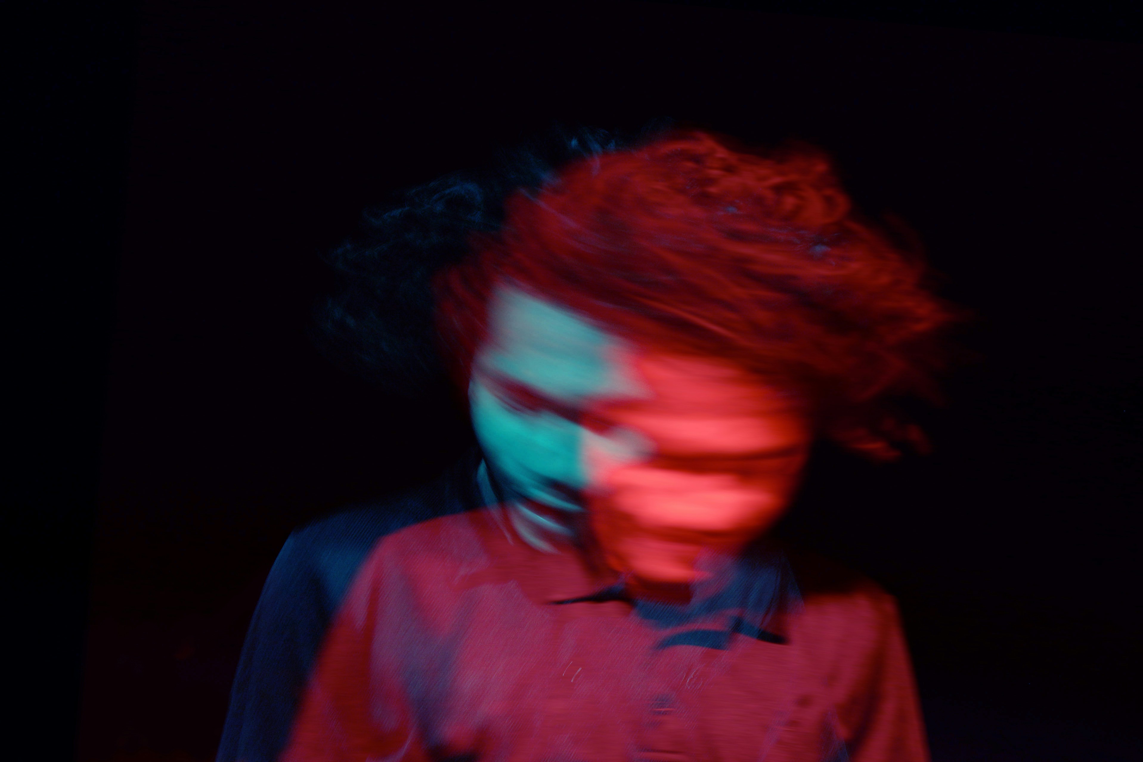 blurry image of a person engaging in hippie flipping against a dark background